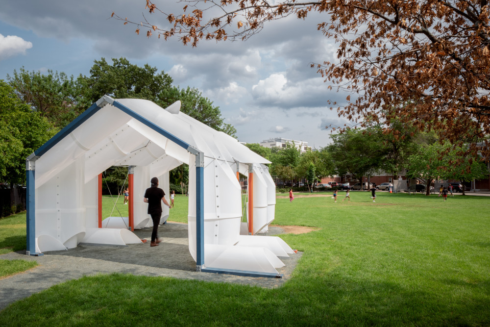 The CloudHouse structure sits in the corner of the park with its open form facing the center.